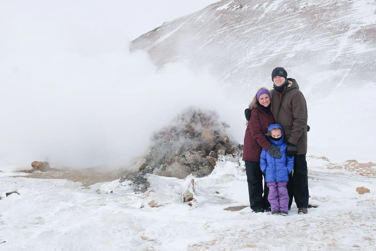 Family enjoying a geothermal steam vent in North Iceland